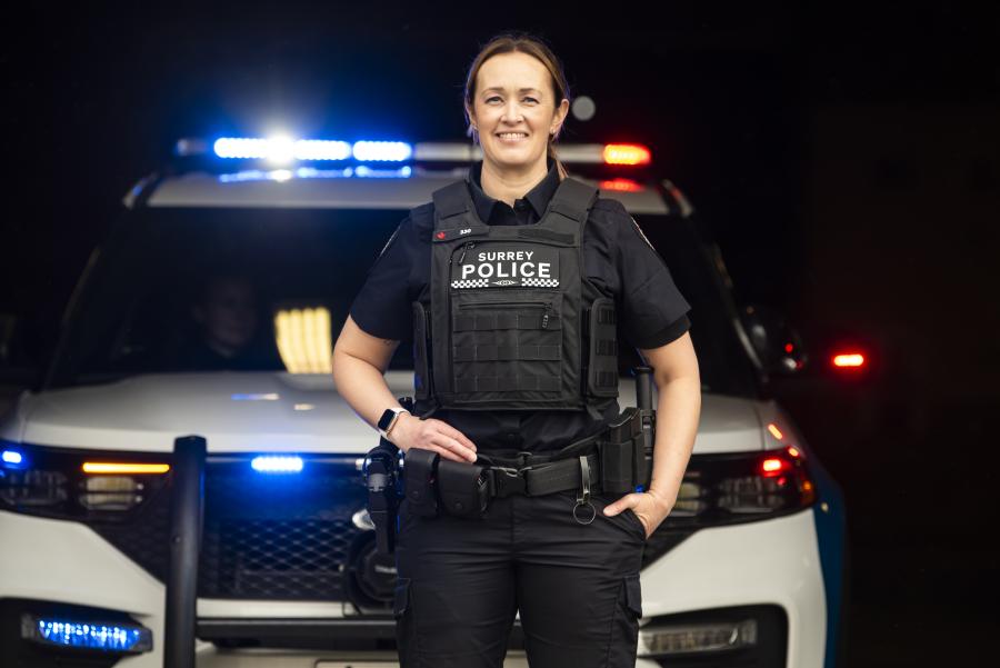 Officer standing in front of police car