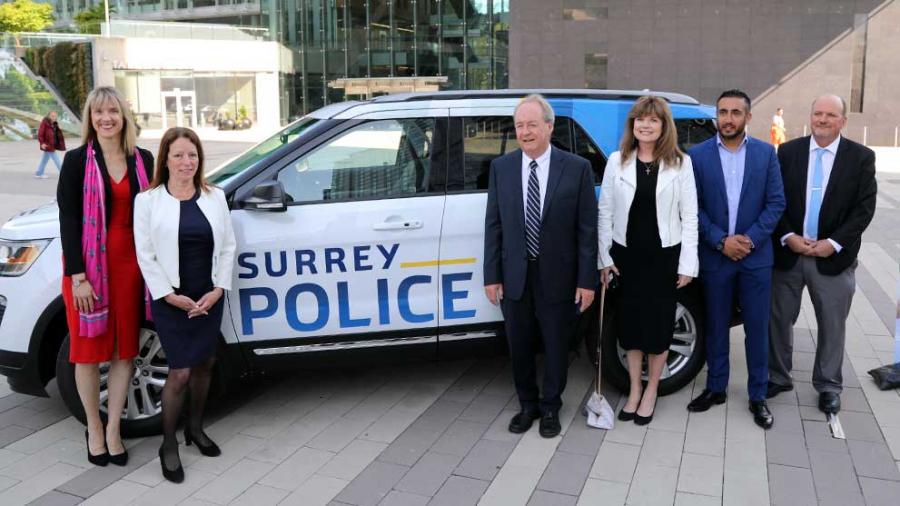 Six people stand in front of Surrey Police mock-up vehicle
