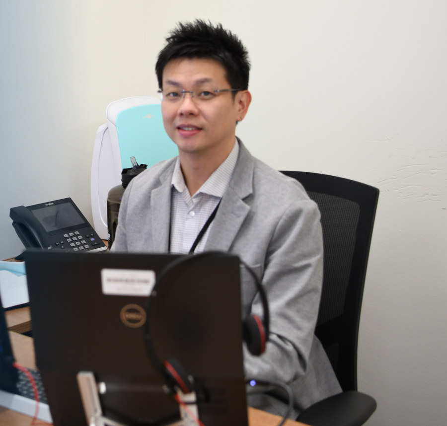 Nathan Wong sitting at his desk in front of a computer